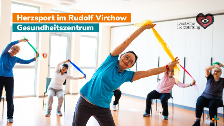 Gruppe älterer Teilnehmer in einem hellen Gymnastikraum beim Herzsport oder Reha-Training. Die Personen führen Dehnübungen mit farbigen Schwungtüchern durch, das Logo der Deutschen Herzstiftung ist sichtbar.
