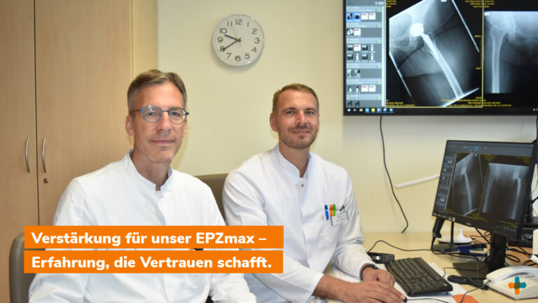 Zwei Ärzte in weißen Koffern (Arztkitteln) vor Bildschirmen mit Röntgenaufnahmen einer Hüftprothese.
