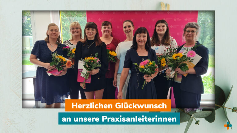 Gruppenfoto von acht lächelnden Praxisanleiterinnen des DRK mit Blumensträußen und Urkunden bei einer Gratulationsfeier.