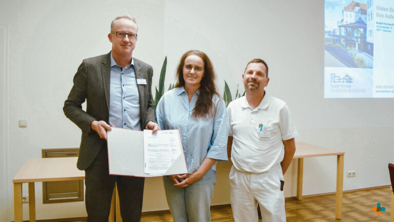 Zertifikatsübergabe im Rudolf-Virchow-Klinikum Glauchau mit Geschäftsführer Christian Wagner (links), der neuen Chefärztin Anke Gündel (Mitte) und einem Mitarbeiter in medizinischer Arbeitskleidung (rechts).