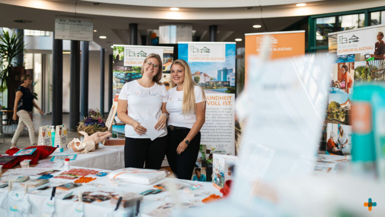 Zwei lächelnde Mitarbeiterinnen am Informationsstand des Klinikums Glauchau beim Tag der offenen Kreißsaaltür.